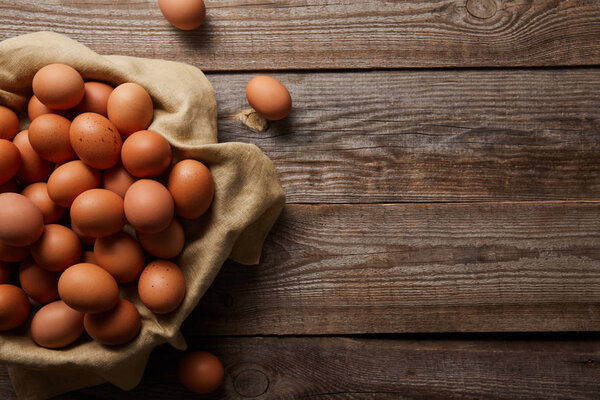  top view of chicken eggs at cloth on wooden table