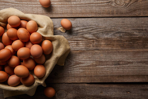  top view of chicken eggs at cloth on wooden table