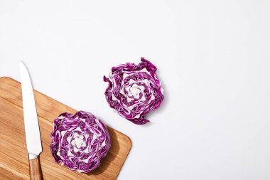 top view of red cabbage on wooden chopping board and knife on white background clipart