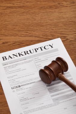 bankruptcy form under wooden gavel on brown wooden table clipart