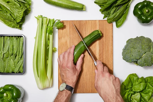 Vista Superior Del Hombre Cortar Verduras Verdes Sobre Tabla Cortar — Foto de Stock