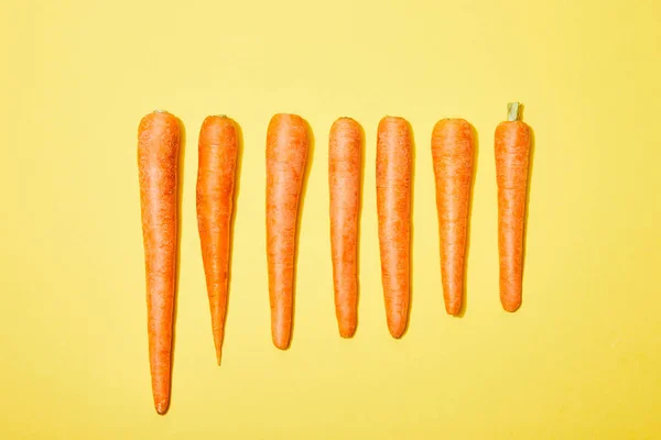 Vista Superior Zanahorias Fila Sobre Fondo Amarillo —  Fotos de Stock