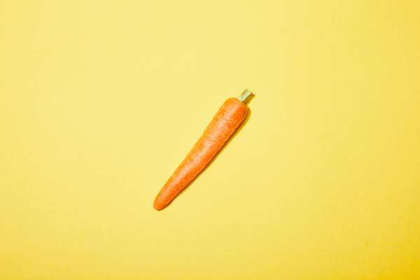 top view of organic carrot on yellow background