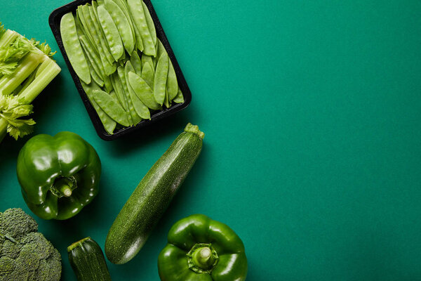 top view of green fresh vegetables on green background