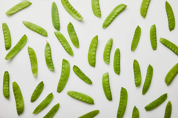 top view of green peas scattered on white background