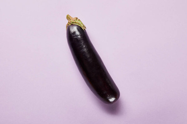top view of ripe whole eggplant on violet background with copy space