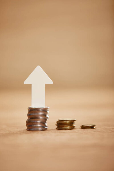 увеличение диаграммы из монет с белой стрелкой вверх, концепция финансового роста
