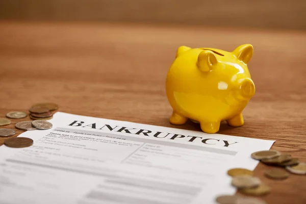 破産形態の選択的焦点 コイン 木製テーブル上の黄色の貯金箱 — ストック写真