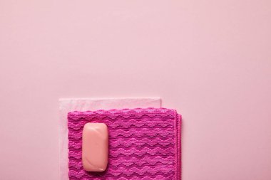 top view of pink rags and soap on pink background  clipart