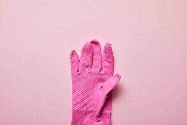 top view of bright and colorful rubber glove on pink background  clipart