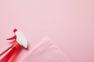 pembe arka plan üzerinde sprey ile pembe bez ve şişe üst görünümü 