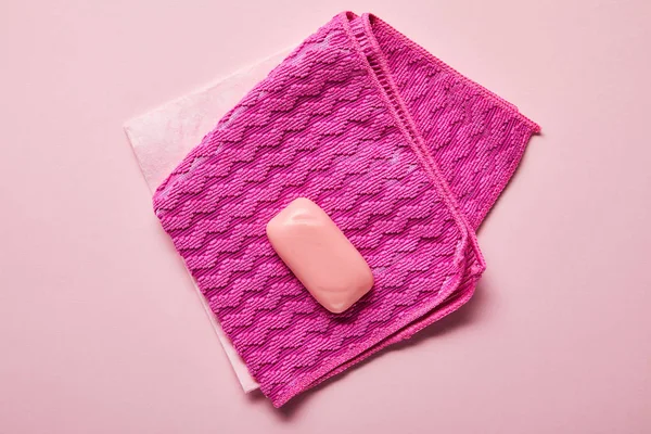 粉红色抹布和肥皂在粉红色背景的顶视图 — 图库照片