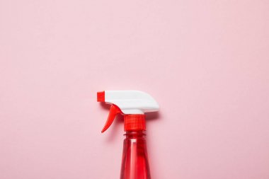 pembe arka plan üzerinde sprey ile kırmızı şişe üst görünümü 
