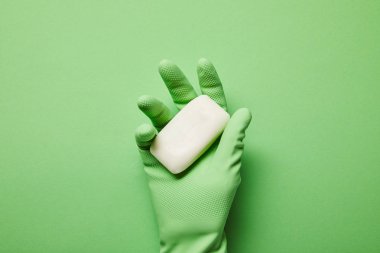 cropped view of man in rubber glove holding white soap  clipart