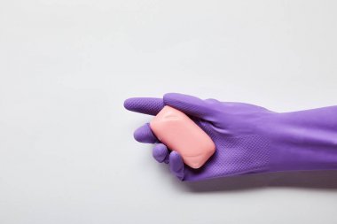 cropped view of man in purple rubber glove holding pink soap  clipart