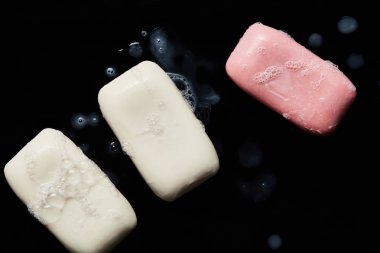 siyah arka plan üzerinde damla ile pembe ve beyaz sabunlar üst görünümü 
