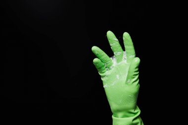 cropped view of man in rubber glove with foam isolated on black clipart