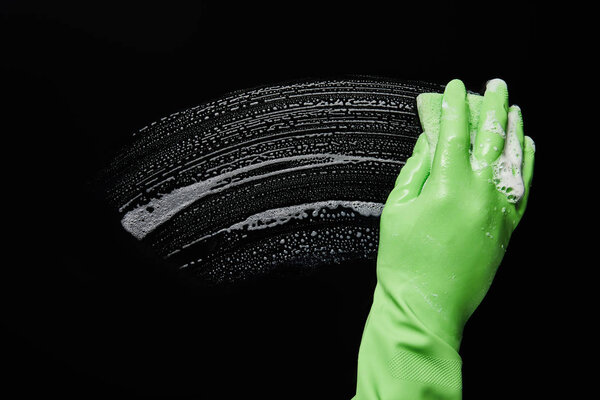 cropped view of man in green rubber glove cleaning with sponge 