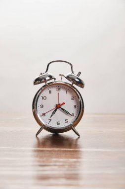gri izole ahşap masa üzerinde gümüş çalar saat 