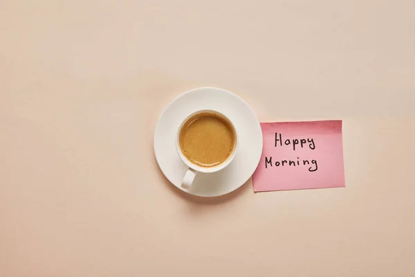咖啡和粘滞便笺的顶视图与米色背景上快乐的早晨字母 — 图库照片