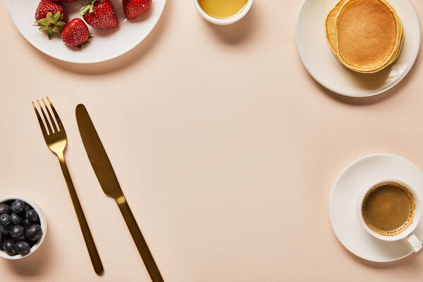 top view of served breakfast with berries, coffee, pancakes and empty space in middle