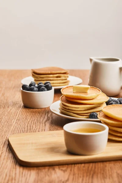 Selective Focus Plates Pancakes Berries Honey Bowl Syrup Jug Isolated — Stock Photo, Image
