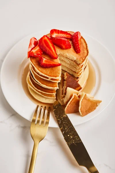 Teller Mit Pfannkuchen Und Pfannkuchen Mit Erdbeeren Neben Goldenem Besteck — Stockfoto