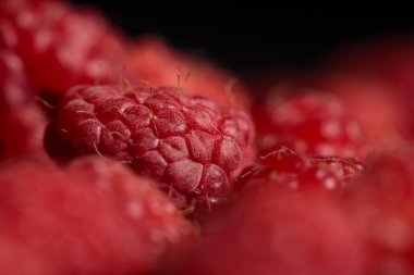 selective focus of delicious ripe raspberry isolated on black clipart