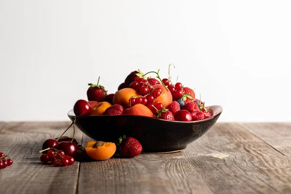 白で隔離された木製のテーブルの上に混ぜたおいしい熟した果実を混ぜたプレート — ストック写真