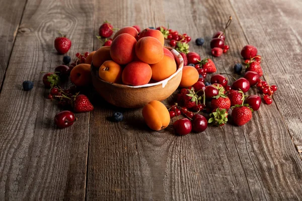 Reife Köstliche Saisonale Beeren Verstreut Schüssel Mit Aprikosen Auf Holztisch — Stockfoto