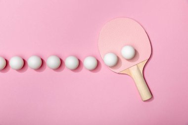 flat lay with white table tennis balls and racket on pink background clipart