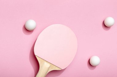 pembe arka plan üzerinde pembe raket yakın dağınık beyaz masa tenis topları üst görünümü