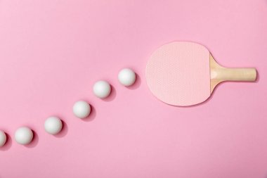 masa tenisi topları ve pembe arka plan üzerinde pembe raket üst görünümü