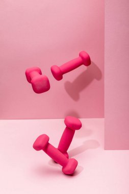 pembe arka planda havada uçan pembe parlak halter