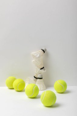 Beyaz arka planda beyaz badminton top ve sarı tenis topları