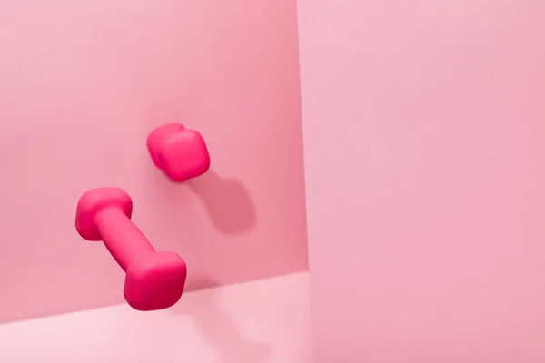 Roze Heldere Dumbbells Vliegen Lucht Roze Achtergrond Met Kopieer Ruimte — Stockfoto