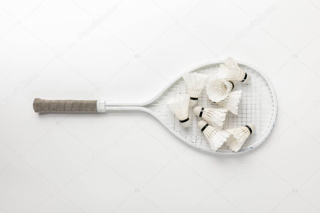 top view of white badminton racket with shuttlecocks on white background