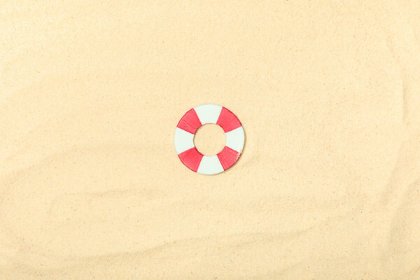 top view of paper beach with lifebuoy on textured sand 
