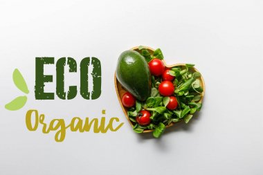 eko organik yazı ile beyaz arka plan üzerinde kalp şeklinde kase taze yeşil sebze üst görünümü