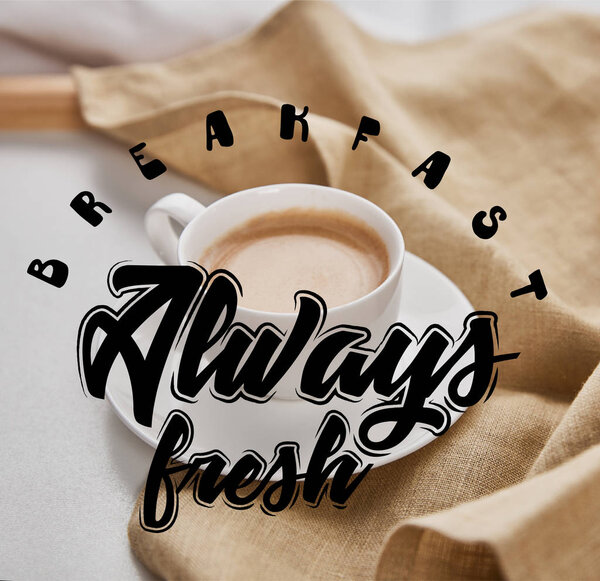 close up view of coffee in white cup on saucer near beige napkin with breakfast always fresh illustration