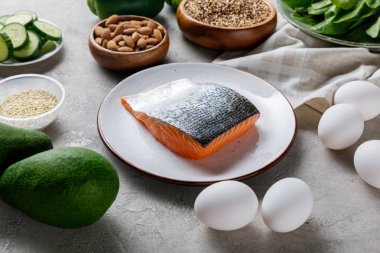 yumurta, fındık ve avokado, ketojenik diyet menüsü yakınında beyaz plaka üzerinde taze çiğ somon