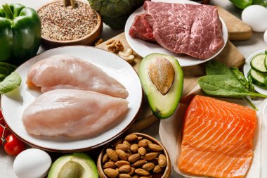 fresh raw salmon, meat and chicken breasts near nuts and vegetables, ketogenic diet menu clipart