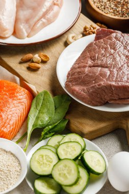 fresh raw salmon, chicken breasts and meat near nuts, spinach, cucucmbers and groats, ketogenic diet menu clipart
