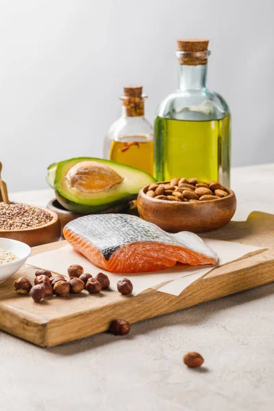 Salmón Crudo Nueces Aguacate Sobre Tabla Cortar Madera Cerca Aceite — Foto de Stock