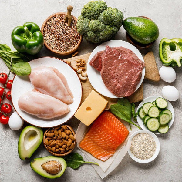 вид сырых кетогенных диетических ингредиентов на деревянной доске на сером фоне с копировальным местом
