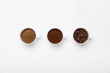flat lay with three types of coffee grinding in cups on white background clipart