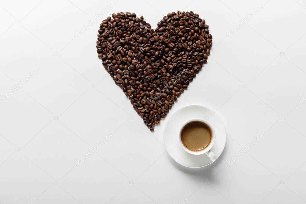 top view of coffee with heart made of coffee grains on white background