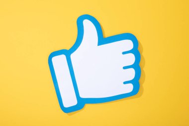 top view of white paper hand with thumb up on yellow background clipart