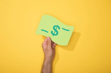 sarı üzerinde dolar banknot kağıt simgesi tutan adam kırpılmış görünümü