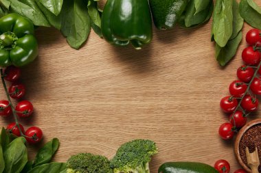 kopya alanı ile yeşil olgun sebze çerçevesi yakınında ahşap kase kırmızı Quinoa üst görünümü